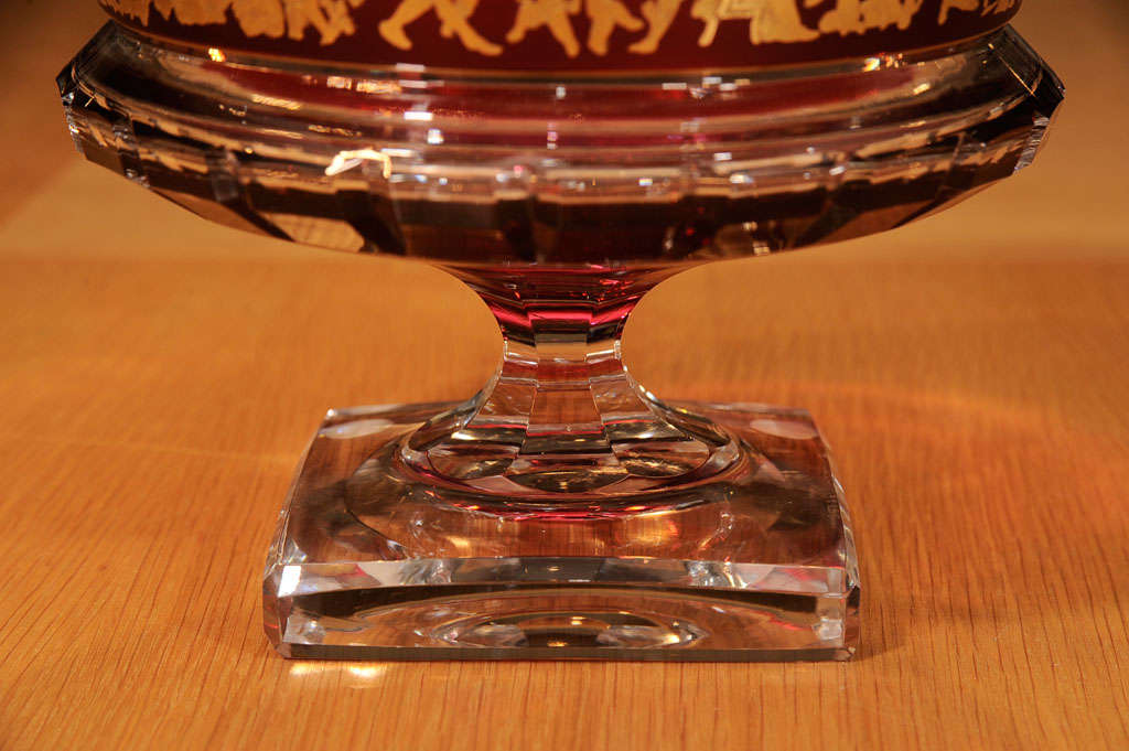 Red glass bowl with gold neoclassic figured frieze on thick clear glass stem and foot.