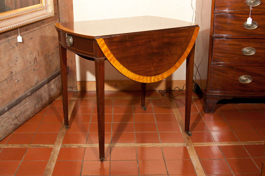 Dieser muntere kleine Mahagoni-Pembroke hat alles, was das Herz begehrt. Die helle Kreuzleiste aus Satinholz kündigt seine Anwesenheit an, und die Satinholzschnur auf der geschwungenen Schubladenfront unterstreicht dieses Gefühl. Die sich