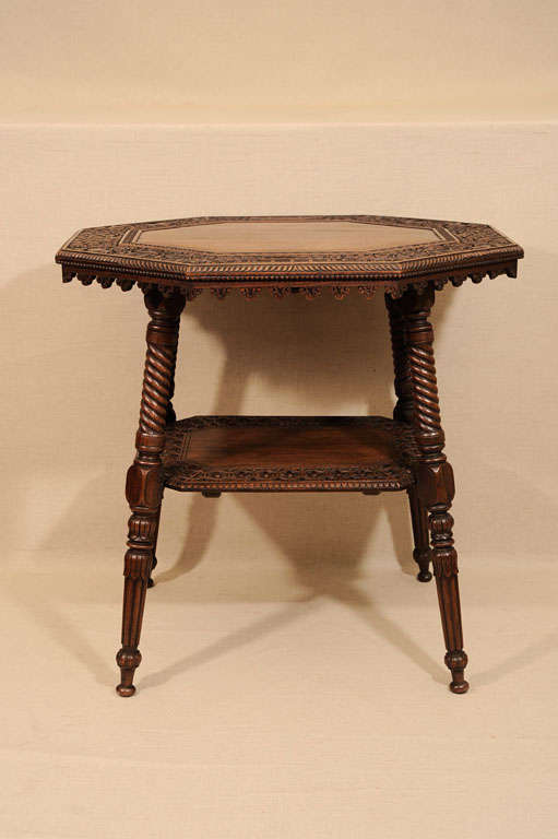 Distinctive Anglo-Indian Two-Tier Occasional Table with Well-Carved Top and Lower Shelf in Animal and Floral Motif Supported by Turned Legs and Feet.  India, Late 19th Century<br />
<br />
25 inches wide x 20 inches deep x 24 inches high<br