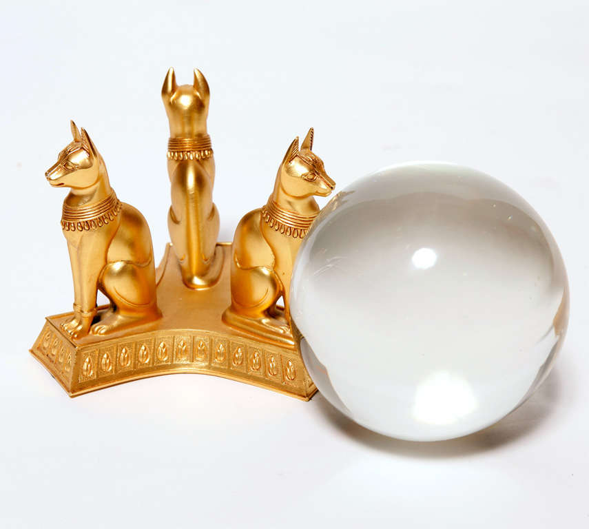 Visionary work of art, a crystal ball held by a sculpted base that represents the Egyptian Bastet , gold plated