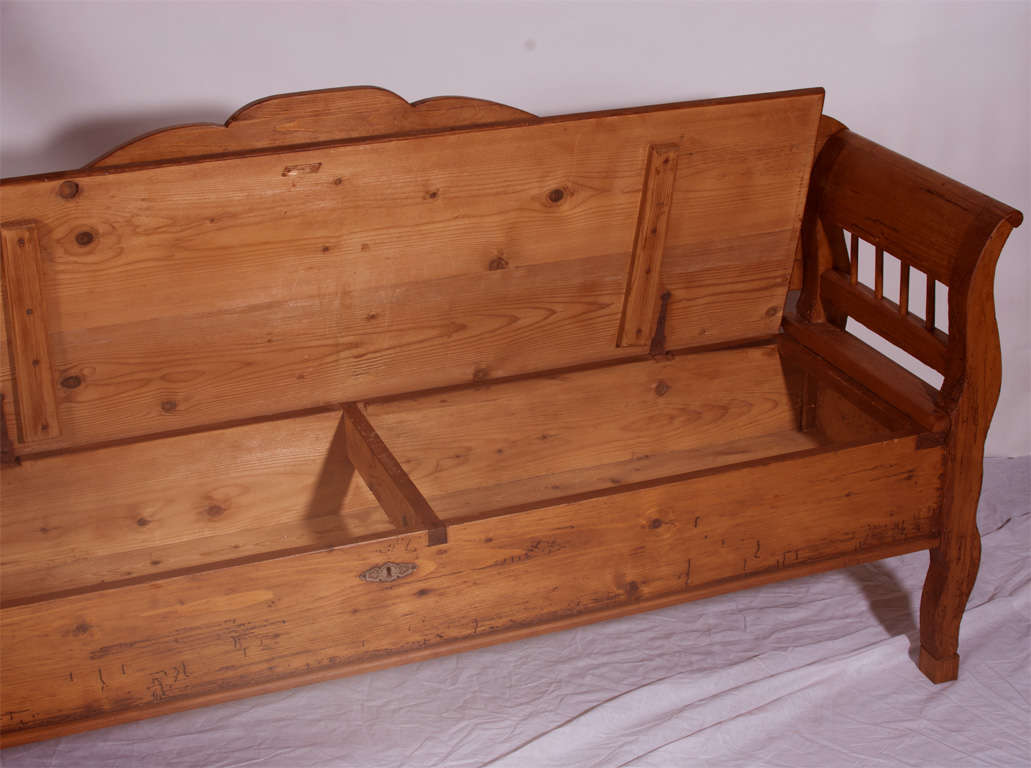 A nicely proportioned bench featuring a scalloped panelled back and curvilinear legs.  The seat lifts on iron strap hinges to reveal a useful storage box.