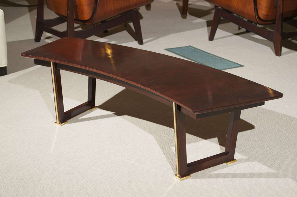 An exceptional Jules Leleu parquetry table in rosewood, uniquely shaped with gilt/bronze detailing on the base, circa 1950. 
Provenance: A private collection, France.