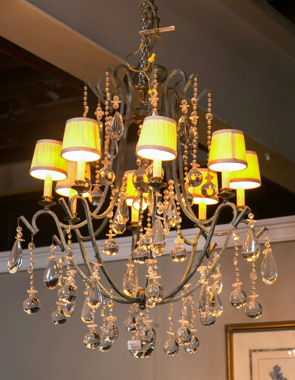A fine Provincial style gilt and iron eight-arm chandelier. Having an elegant flow of open airiness this lighting fixture is surrounded by the elegance of crystal prisms which add warmth and charm to a variety of decor styles. Custom quality.