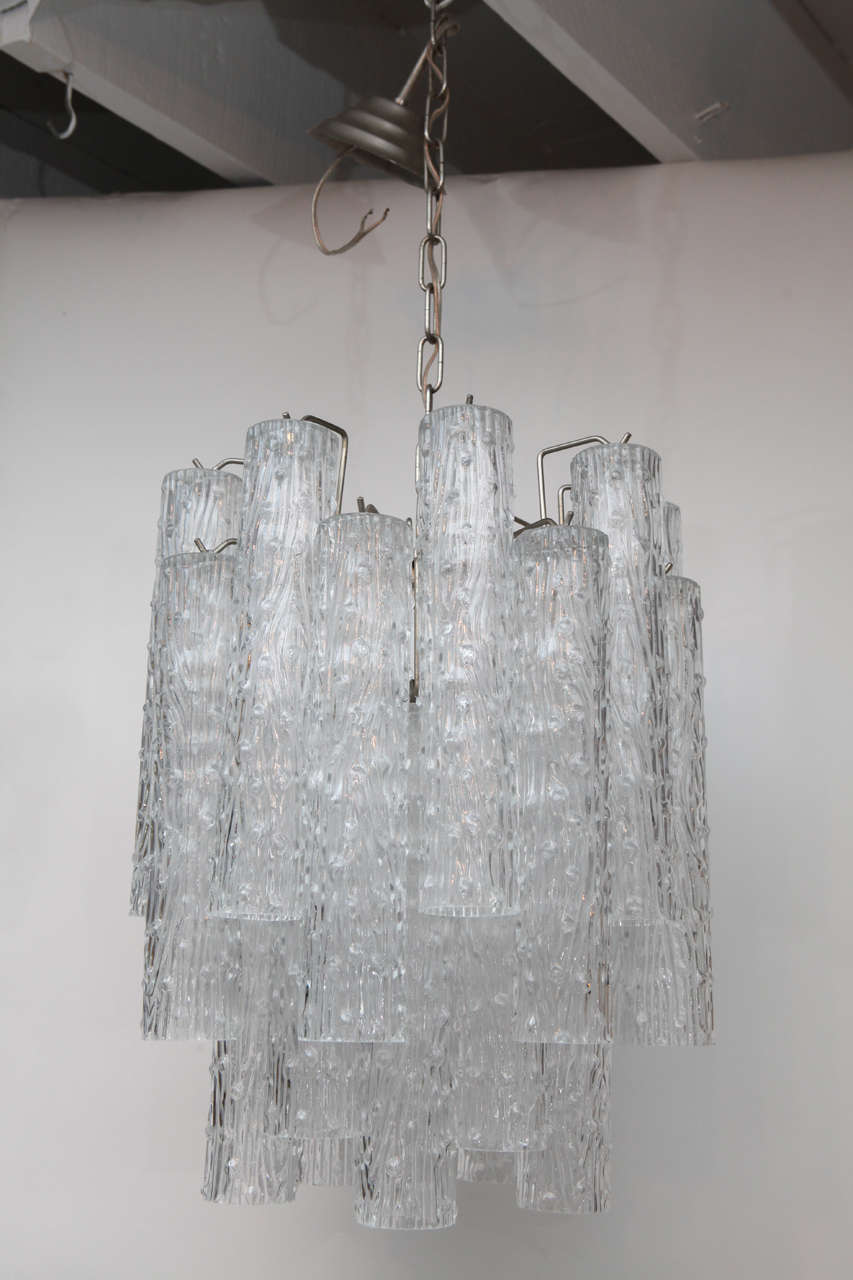 A wonderful compact glass tube chandelier by Kalmar. The are four light sockets. There are a total of 24 glass tubes have an abstract textured design and is 11 3/4