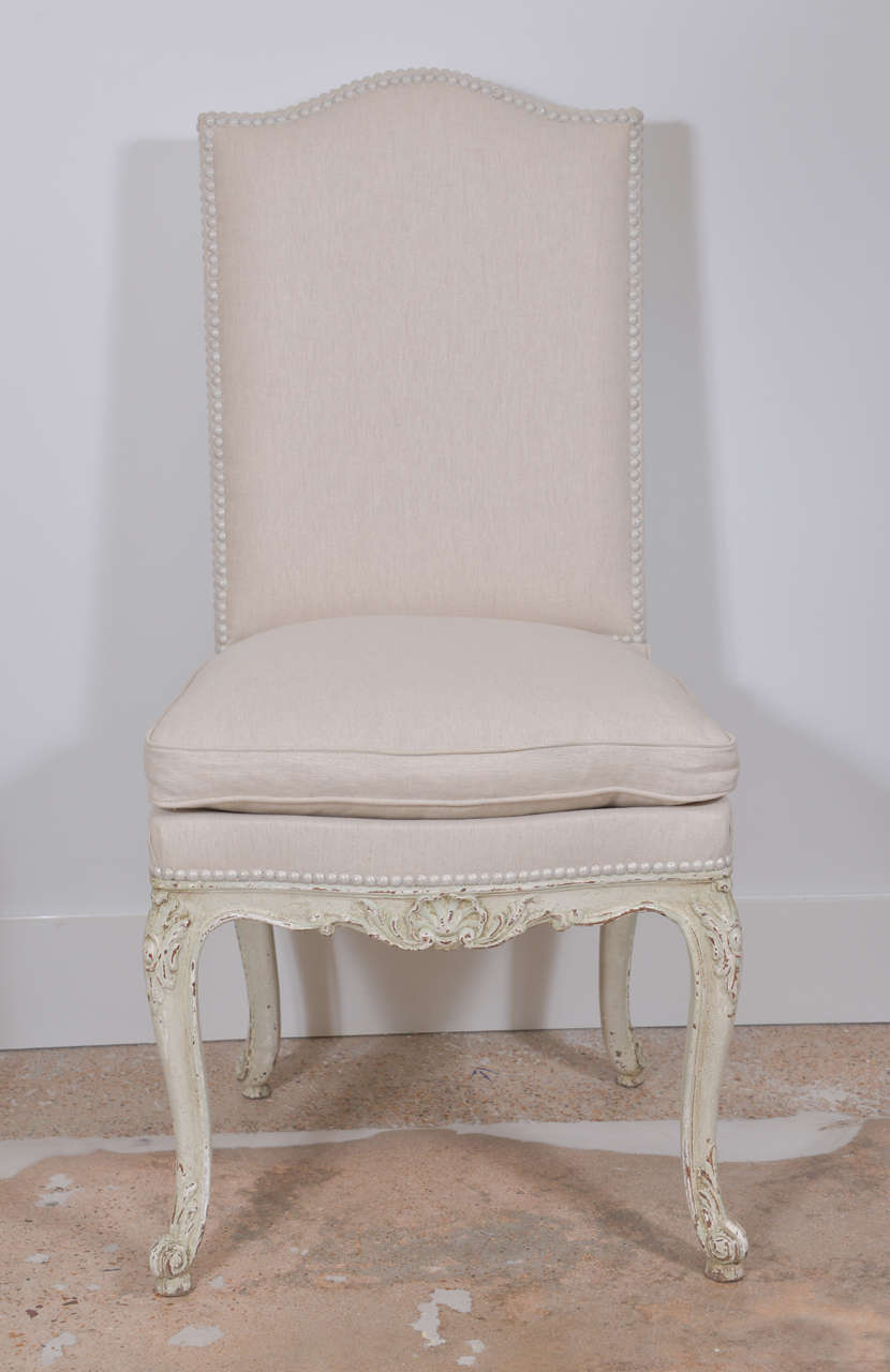 Set of eight painted late 19th century Régence style dining chairs upholstered in off-white linen with nailhead trim.