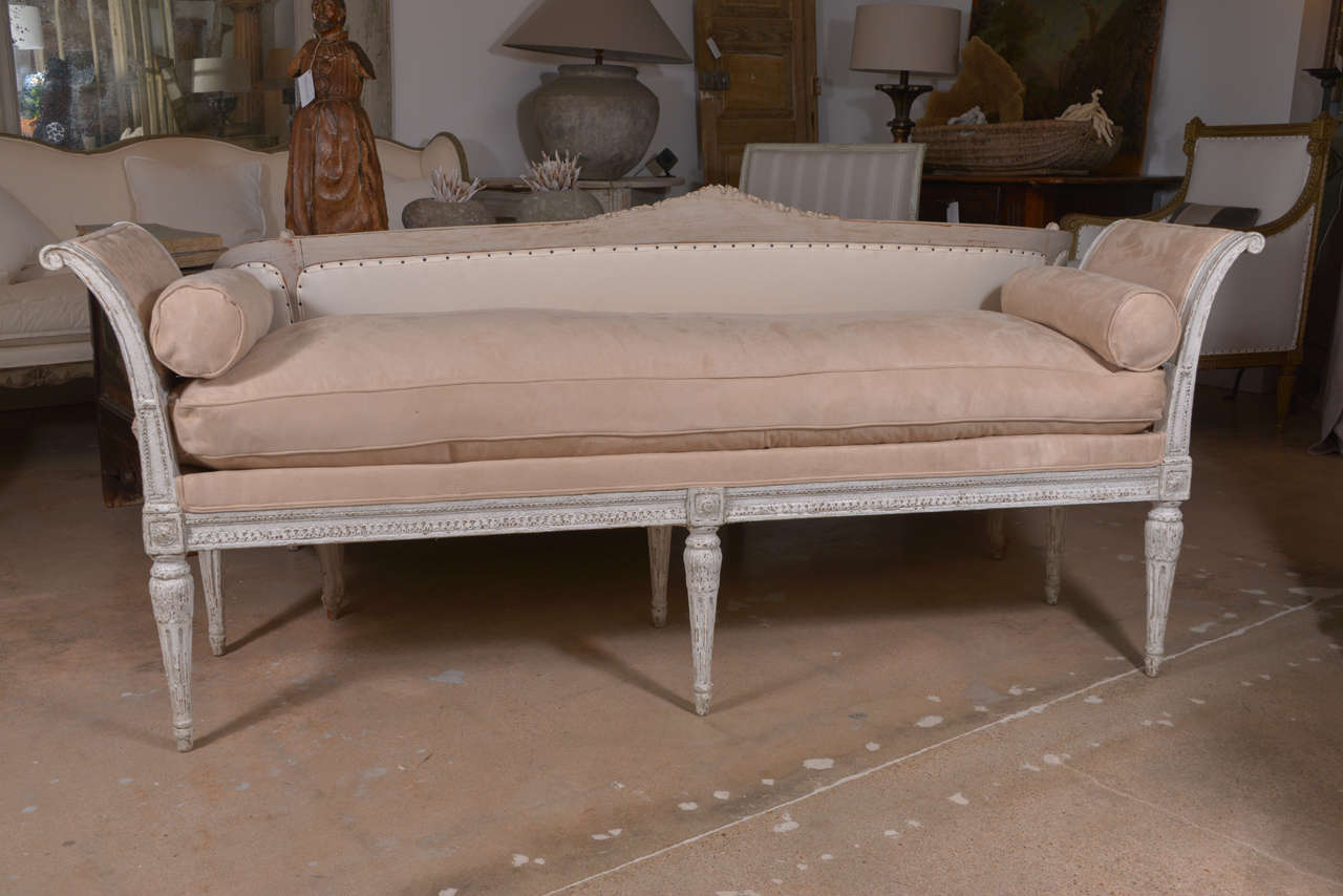 Late 19th century Directoire style painted bench with rolled ends, upholstered in beige with cushions and bolsters.