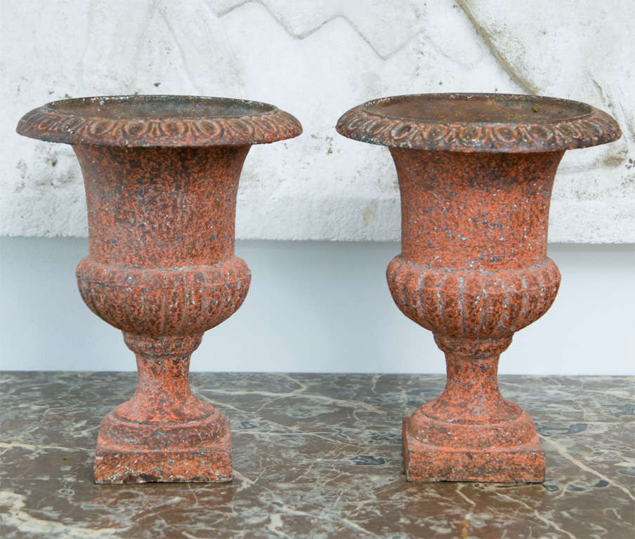 A Pair of red painted medici urns