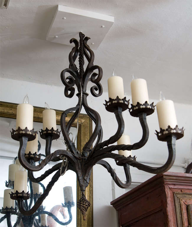 A black painted eight arm heavy cast iron chandelier with large candle lights