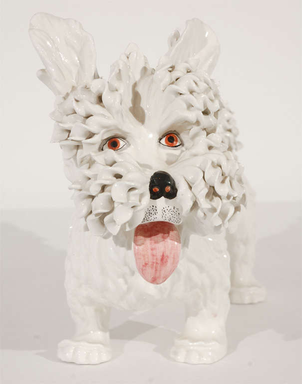 A charming little West Highland Terrier in clay with its tongue sticking out and ruffled details on its muzzle and tail.