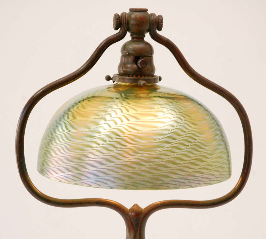 A stunning patinated bronze floor lamp with damascene glass shade. The base is stamped 