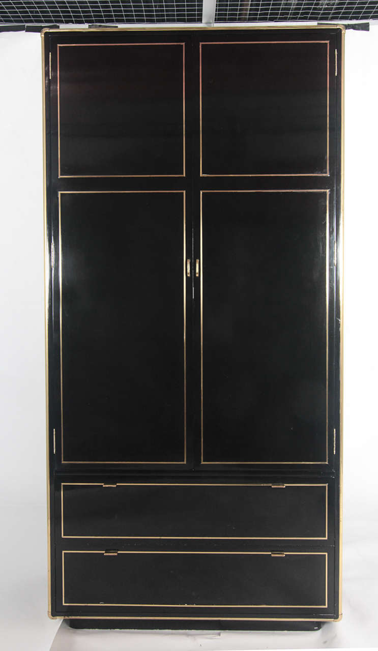 Stunning black lacquer armoire/media cabinet with brass trim and hardware. Doors open to reveal two inner drawers and an upper shelf; cable opening to back as pictured. Made in Spain for John Stuart.

Matching nightstands and credenza also