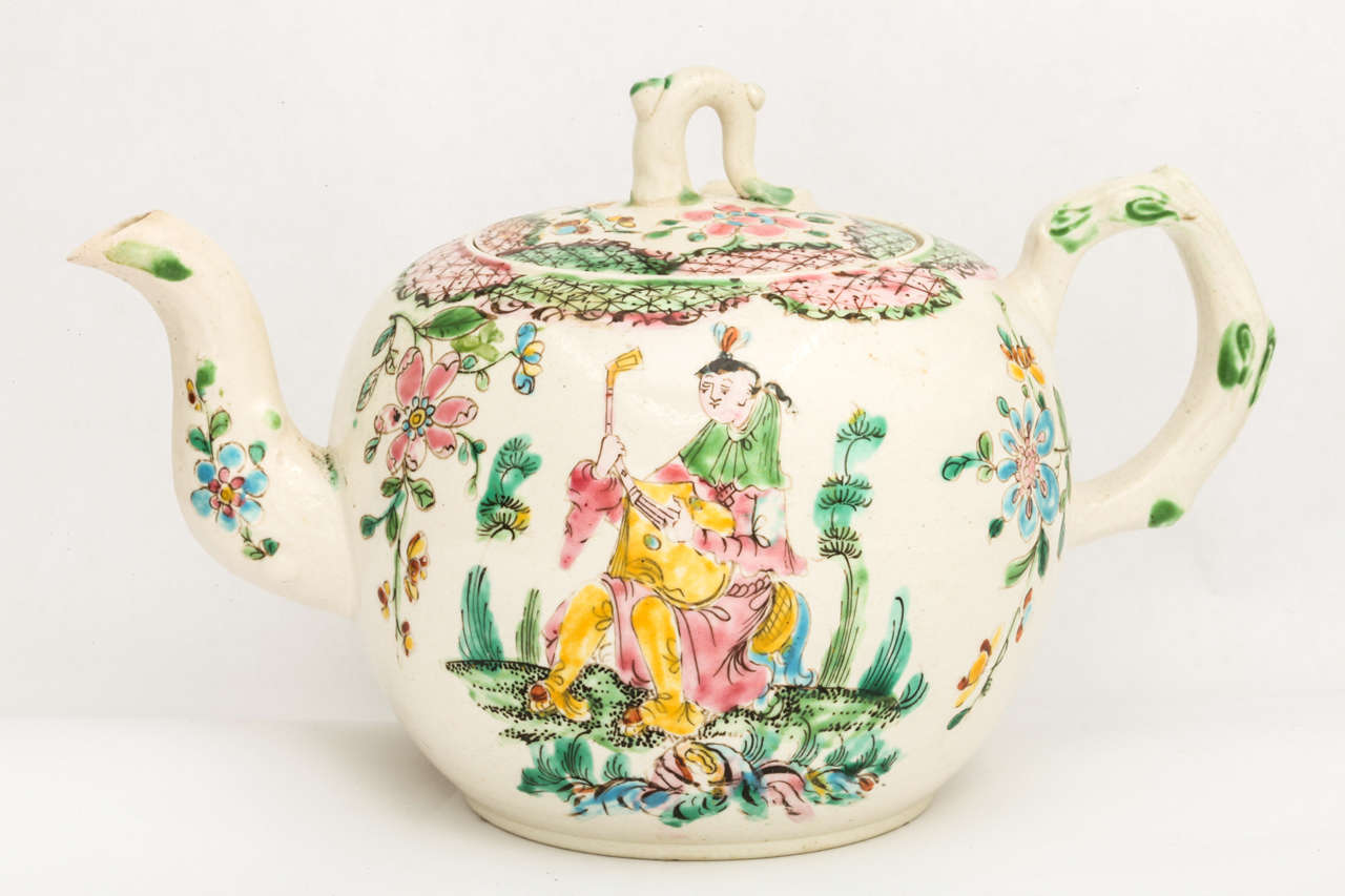 A fine English saltglazed stoneware pottery teapot with crabstock handle and spout , finely painted with Oriental figures and flowers