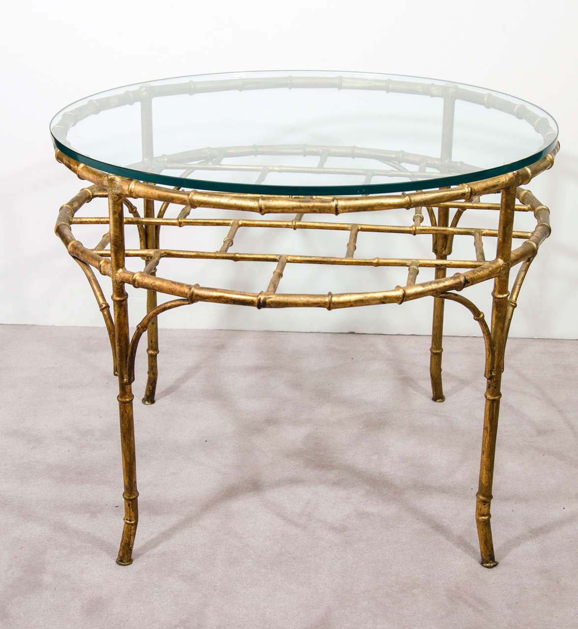 A vintage Italian coffee or cocktail table with a gilt metal bamboo motif base and circular glass surface.