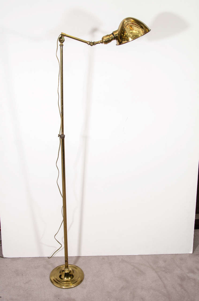 A vintage brass adjustable and expandable industrial floor lamp by Miller Lamp Company. The piece is in good vintage condition with age appropriate patina and wear.
