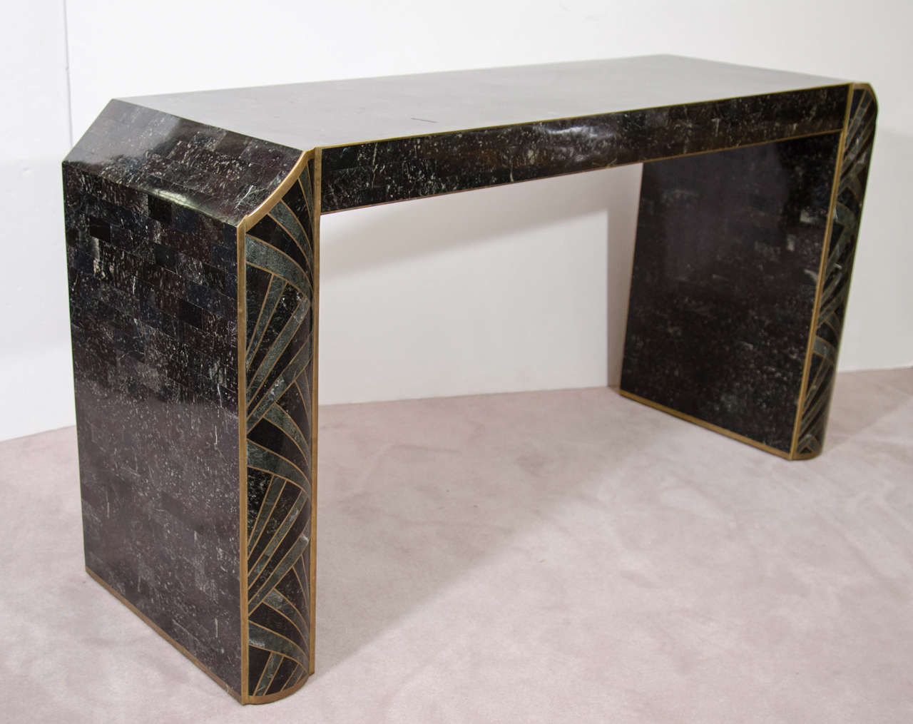 A vintage tessellated stone console table with brass accents. the piece is signed Maitland Smith.