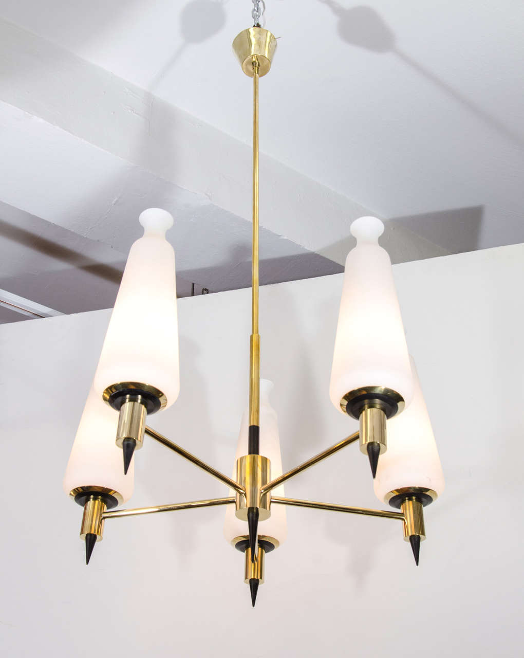 A vintage five-arm brass chandelier with frosted glass shades and black enamel detailing attributed to Stilnovo, circa 1955.  Newly rewired.