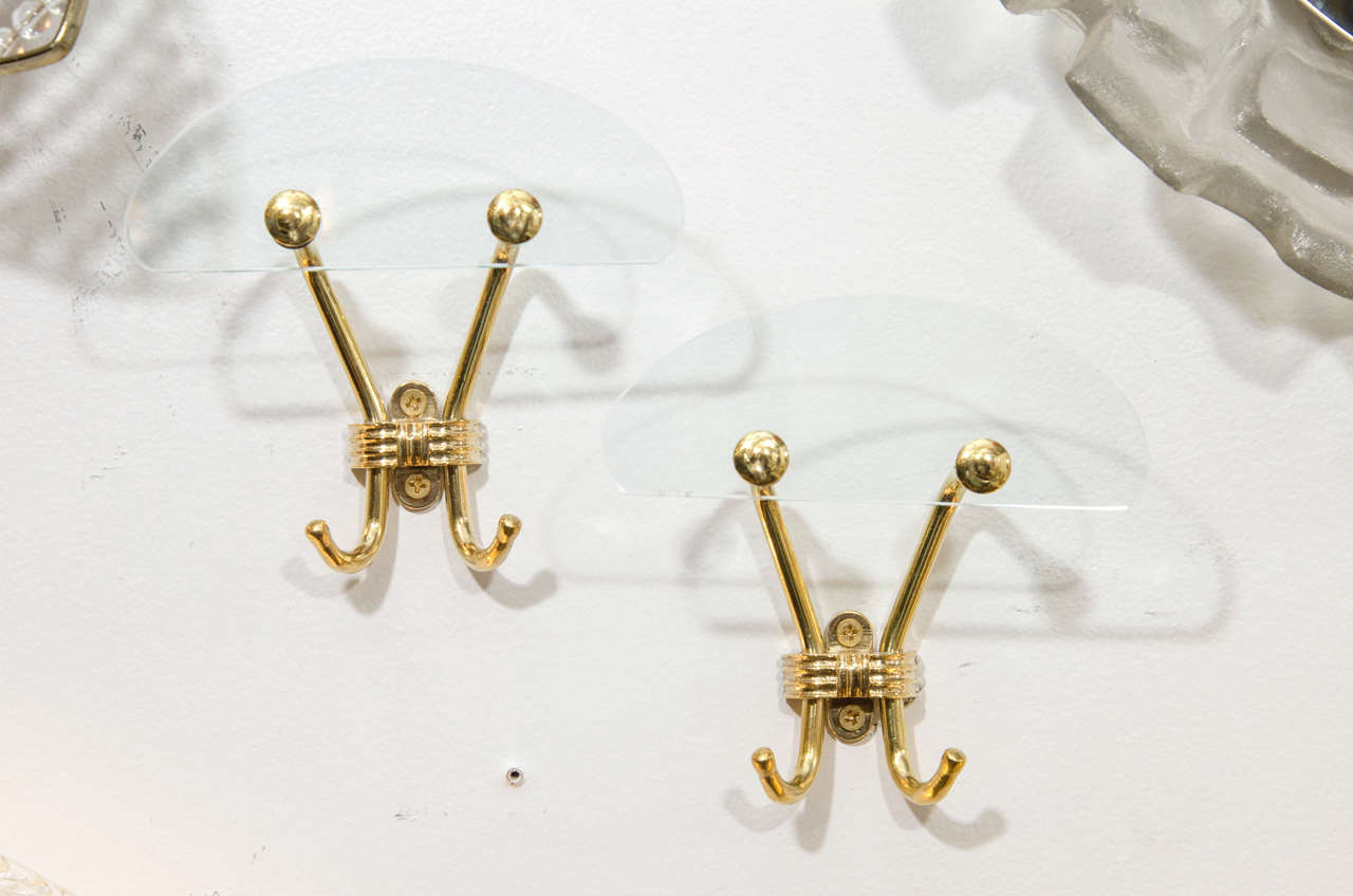 A pair of vintage Italian wall-mounted coat or towel hooks in brass with clear glass accents.