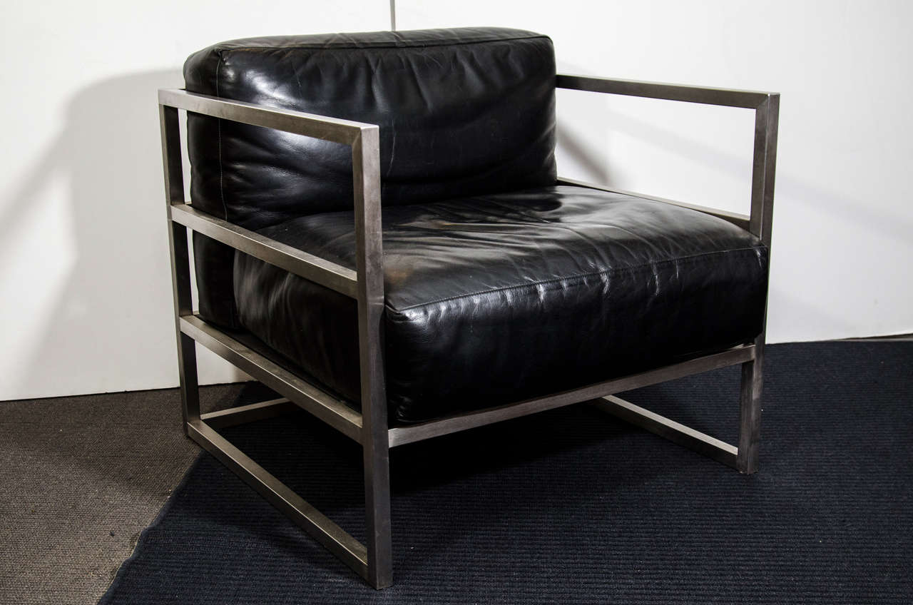 A pair of vintage club chars with black leather cushions and brushed chrome frames.