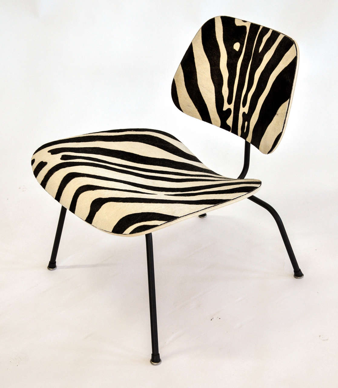 The LCM chair by Charles and Ray Eames for Herman Miller has been expertly reupholstered in a zebra print cowhide.
