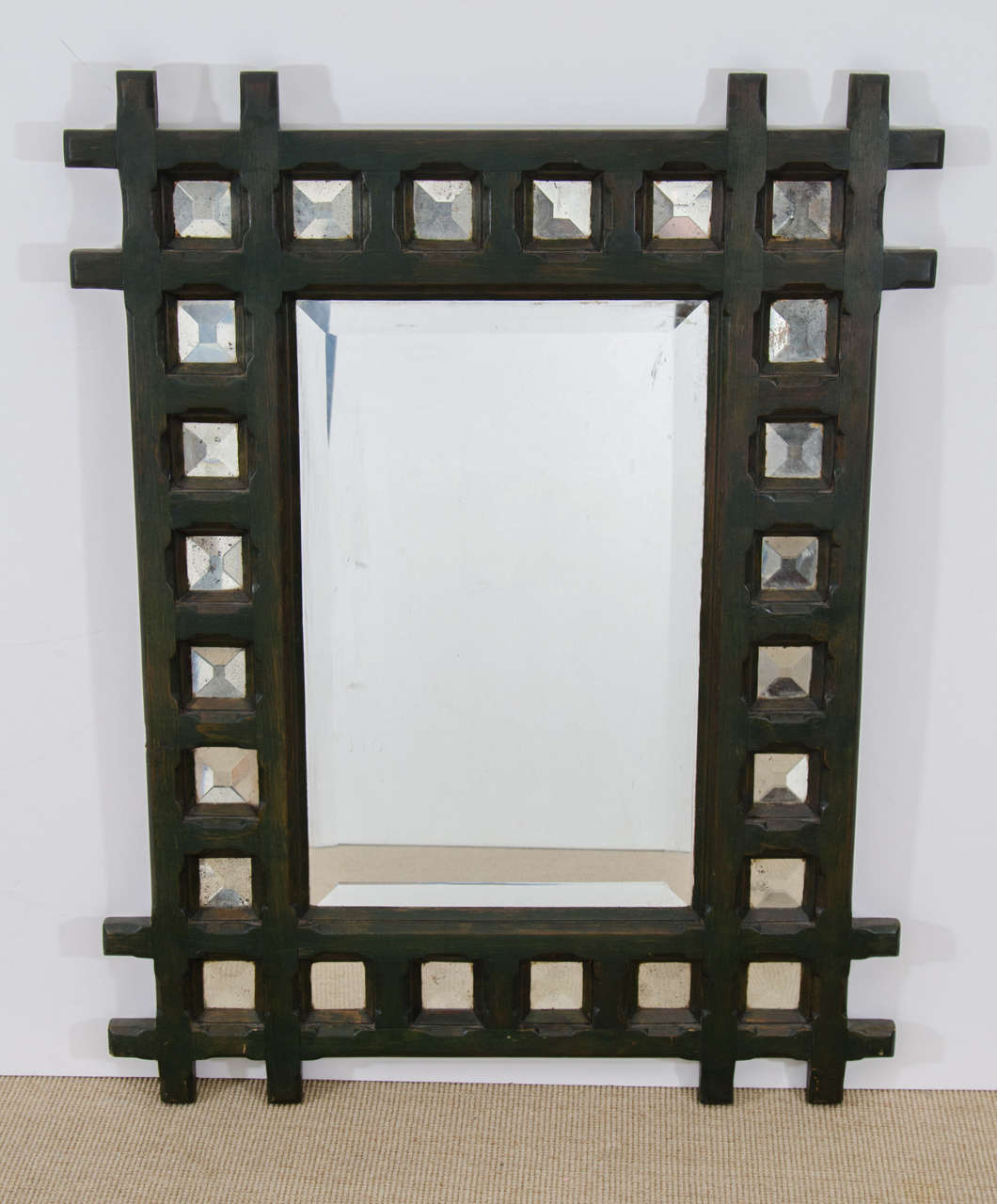 Unusual American Arts & Crafts mirror, circa 1900, original green paint with beautiful aged patina. The mirror is surrounded by smaller bevel cut square mirrors set in a crosshatched wooden frame. Original heavy plank backing. This mirror would add
