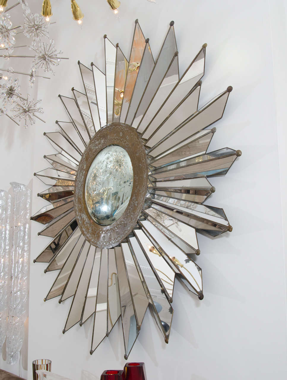 Convex metal sunburst mirror with beveled mirrored ray surround.