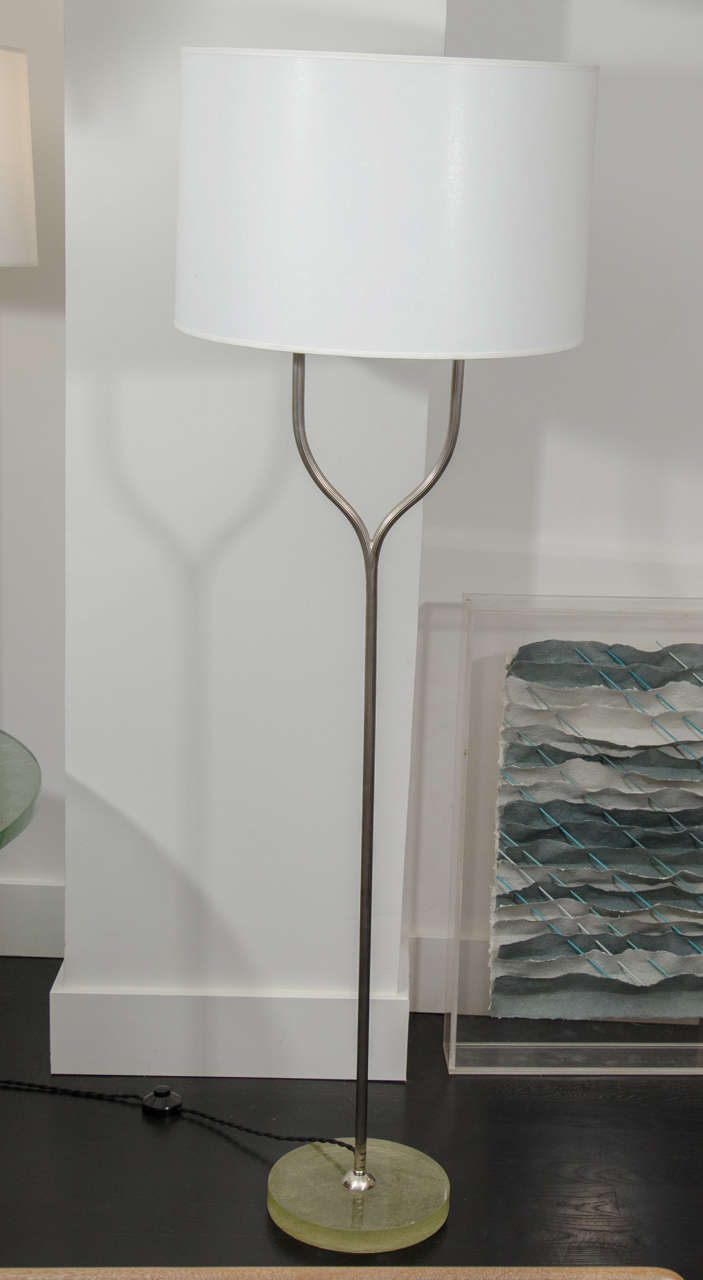 Pair of striated metal floor lamps on Nile glass base. Takes two bulbs and can be customized to have two shades per lamps.
