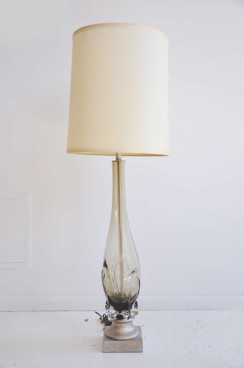 Standing tall, this beautiful smoke Murano glass table lamp lights up any room. Recently updated with new black drum shade and finished with a sleek silver finial for new dramatic look. Please contact for pictures.