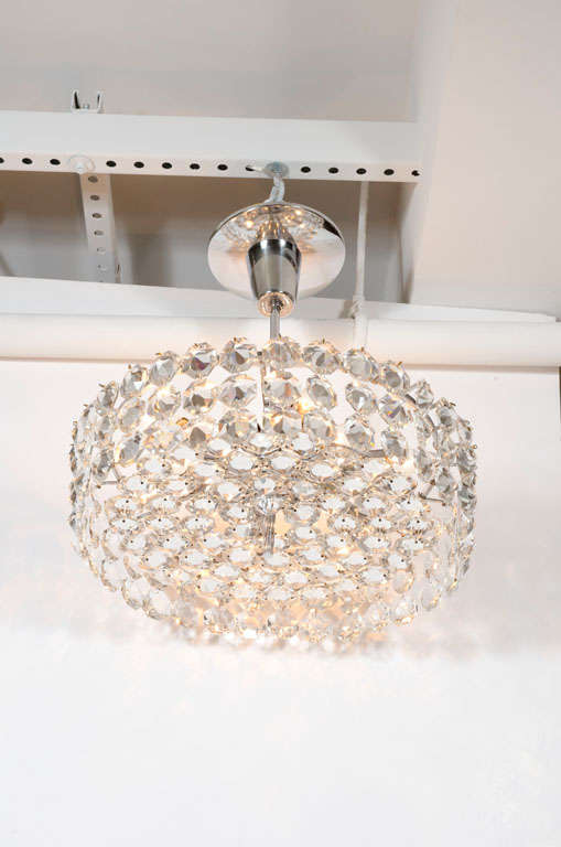 An exquisite chandelier in a drum shape with octagonal faceted crystals on a polished nickel frame with five concentric circles all supported on a polished nickel shaft and canopy with 16 lights. By Bakalowits and Sohne. Austria, circa 1960.