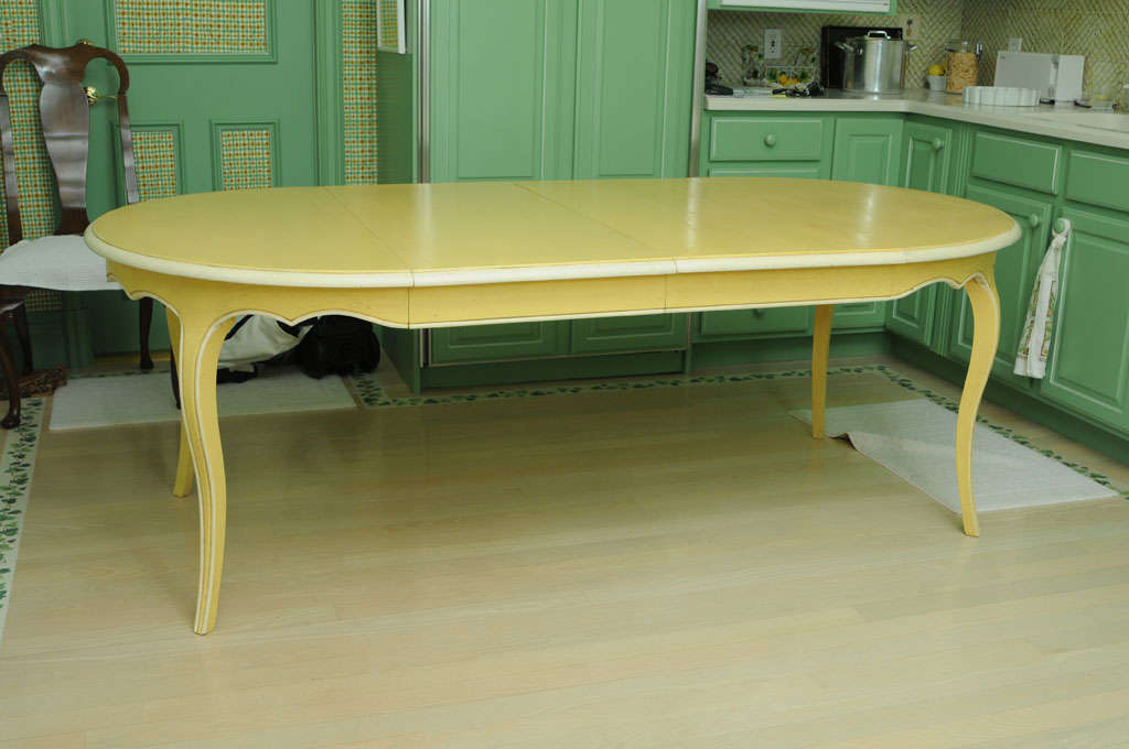 Famous French Furniture Manufacturer DE TONGE distressed painted massive oak dining table round or oval with 2 leaves in a provencal yellow with creamy white detailing. Round 44.5