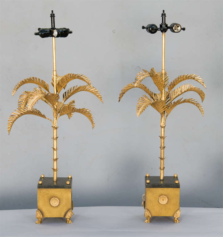 Pair of gilded tole palm tree lamps, each raised on square base raised on paw feet.