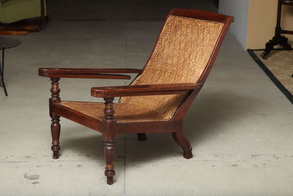Anglo-raj plantation style teakwood bench with caning in basket weave.The slope in the back is at a perfect incline.