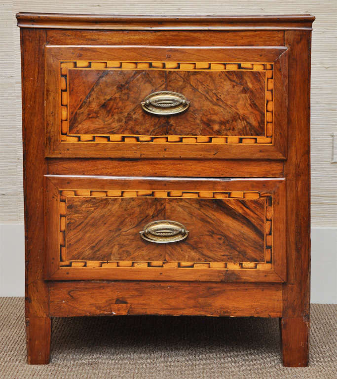 This striking chest with figurative fruitwood features a handsome geometric inlay border pattern.