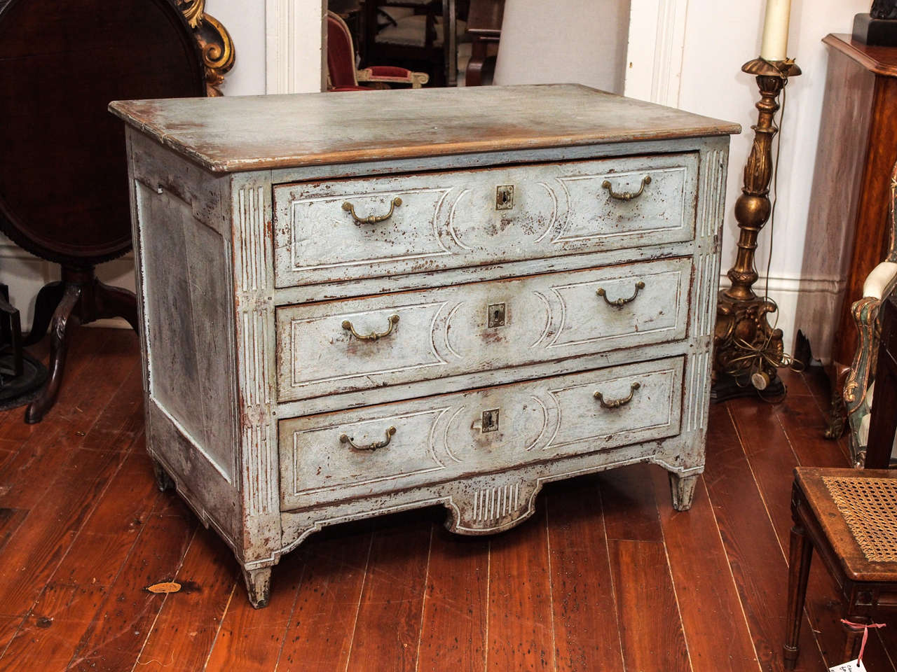 A period walnut 18c. commode with three drawers, with fluted side rails and tapered feet, the bottom with a deep, molded apron.  Pulls replaced, paint not original.