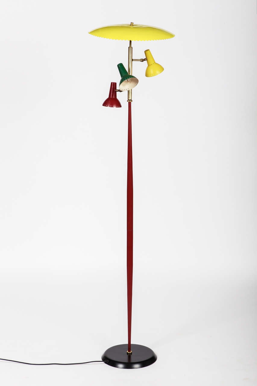 Three lights floor lamp, probably by Arredoluce, circa 1950 
Perfect condition 
Laquared and colored metal and brass 
Measures: H 180cm x 45 cm (cup), base dia. cm 30.