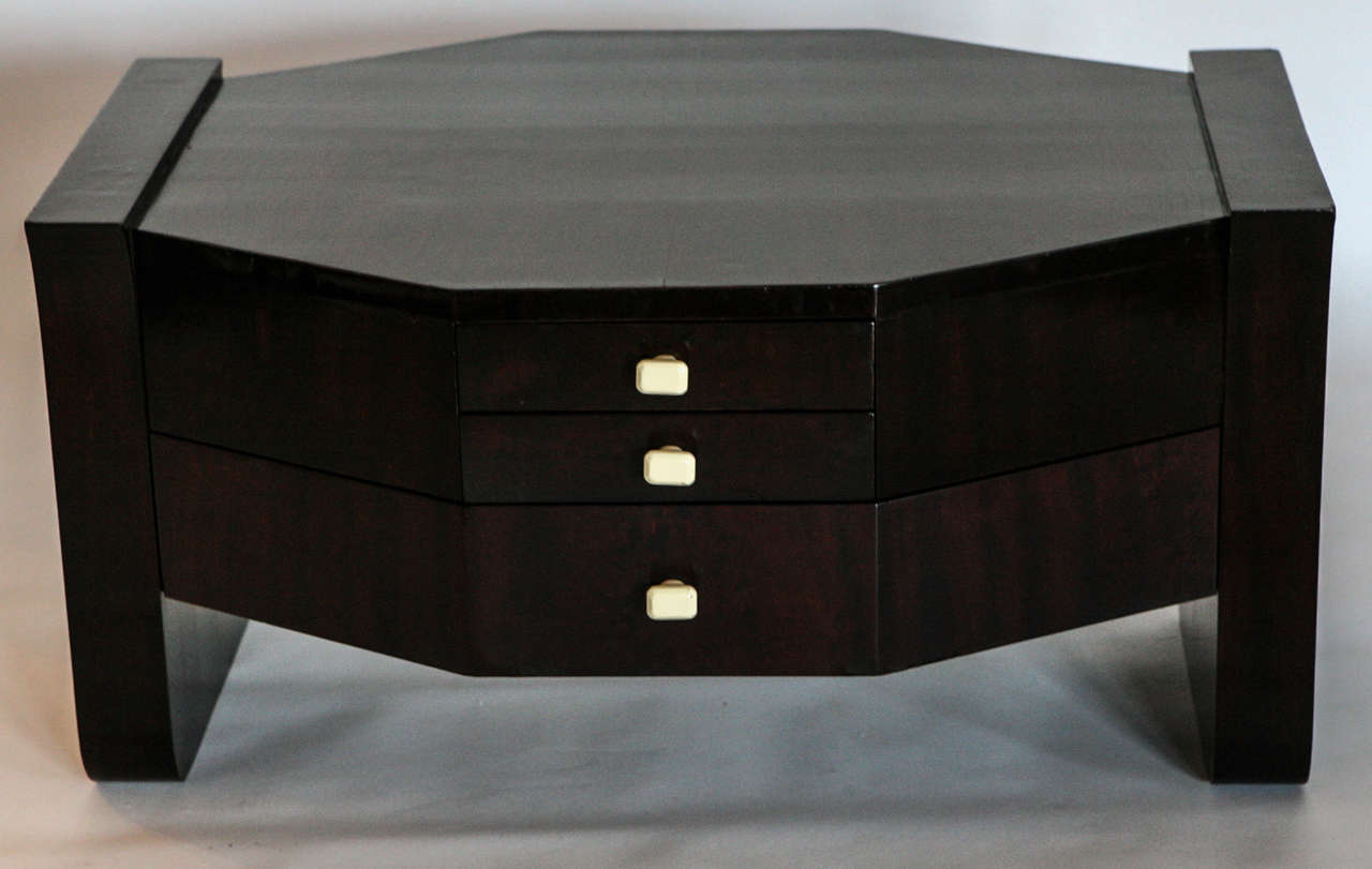 Table has unusual shape. Macassar ebony veneer over mahogany. Three drawers on two sides. Bakelite pulls that imitate ivory. Markings 749953 S.G.