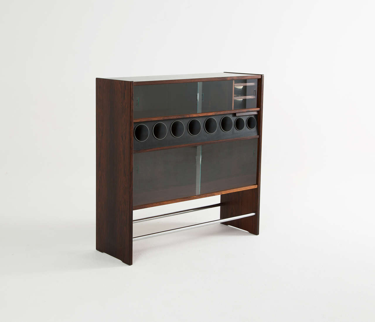 Elegant Danish dry bar, 1960s. The bar shows a lot of interesting lines and stunning details. The front is completely covered in a large piece of rosewood veneer which is in very nice contrast with the chrome footrest. The bar is equipped with a ice