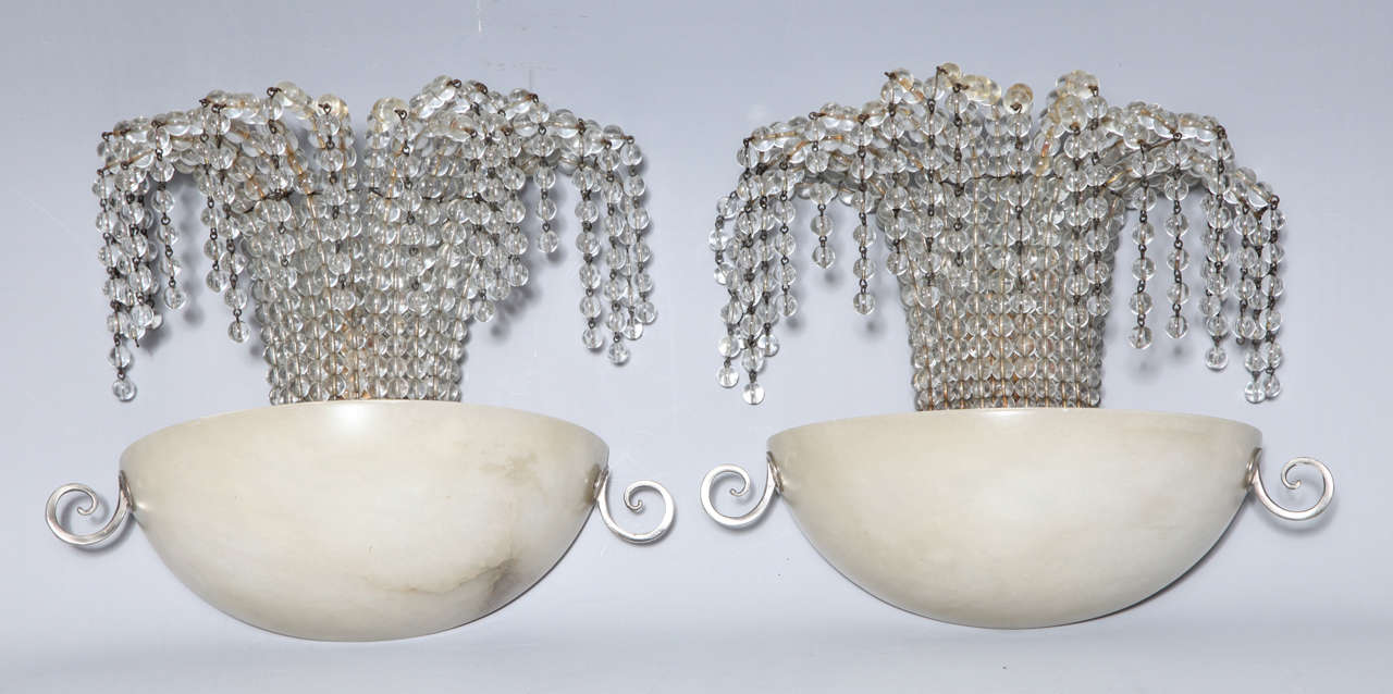 One French Art Deco half moon Alabaster, nickeled bronze and waterfall glass beaded sconce attributed to Bagues. When lit the glass beading sparkles as if they were a fountain spraying water in the sun.