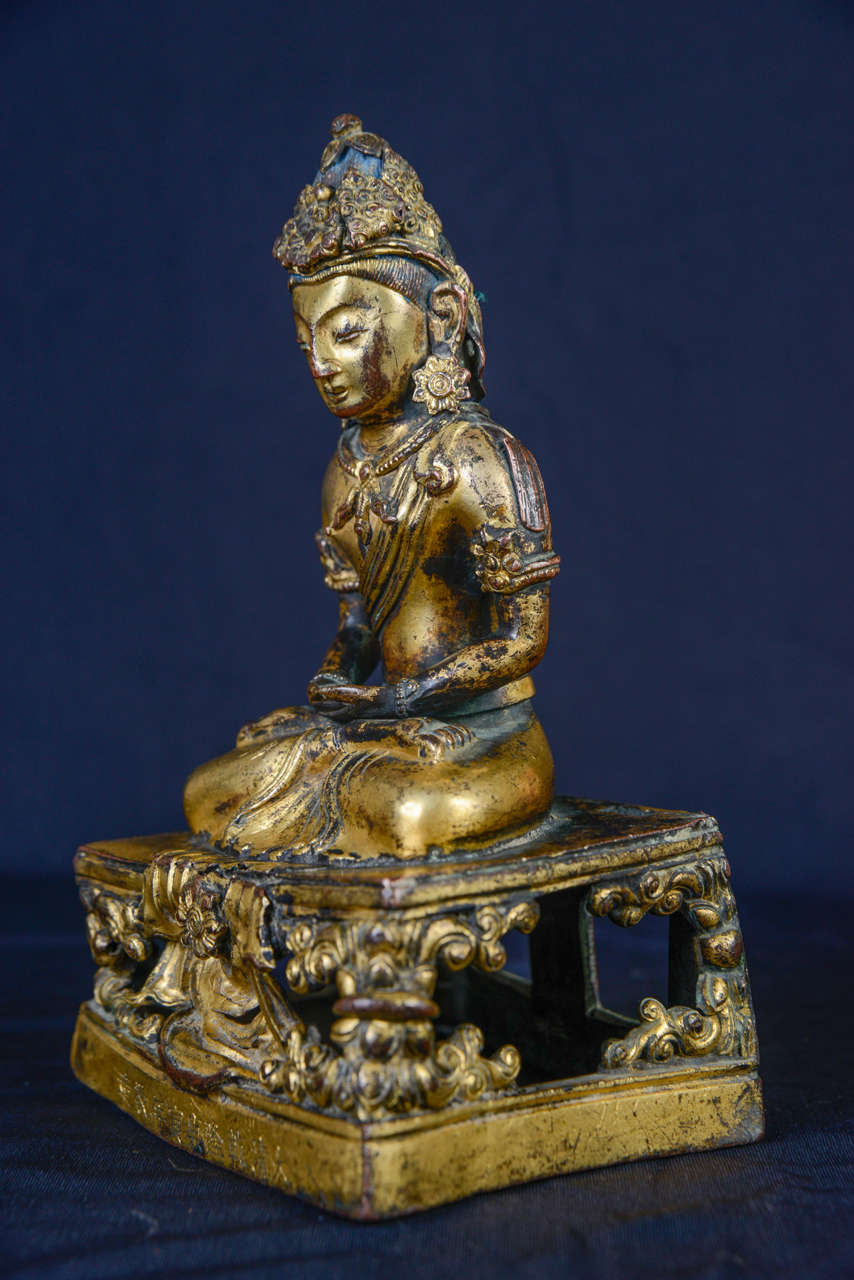 A gilt bronze figure of seated Amitayus on a thron. China Qianlong mark.
circa 1770. Mandorla missing.