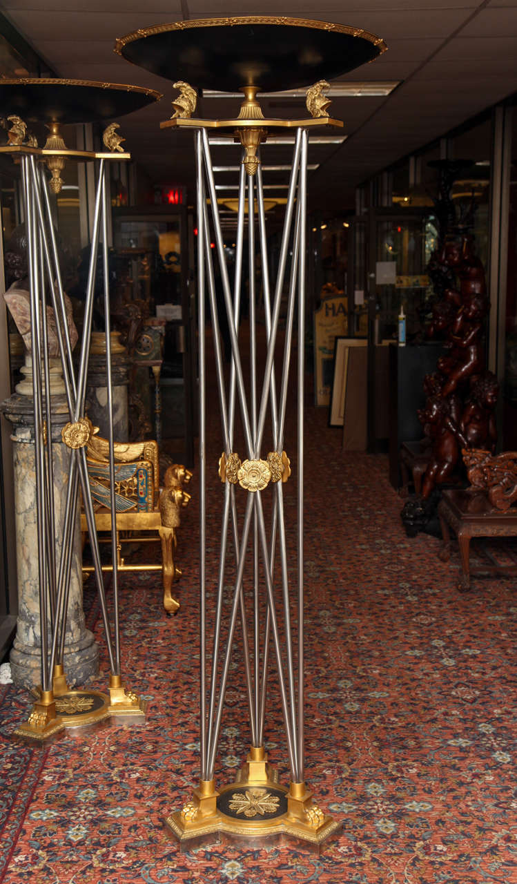 Ein Paar vergoldete und patinierte Bronzefackeln aus Stahl im Empire-Stil. Jede mit einem kreisförmigen flachen Schüssel Form Becken mit einem griechischen Schlüssel und Palmette detaillierte Rand, auf einem kannelierten Sockel und konforme Platte