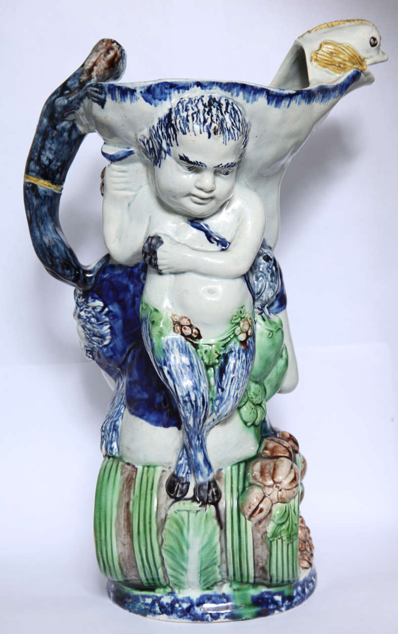 A rare English pearlware Bacchus toby jug, with Bacchus on the front, Pan on the back, a monkey handle and dolphin spout, decorated in underglaze Pratt colors