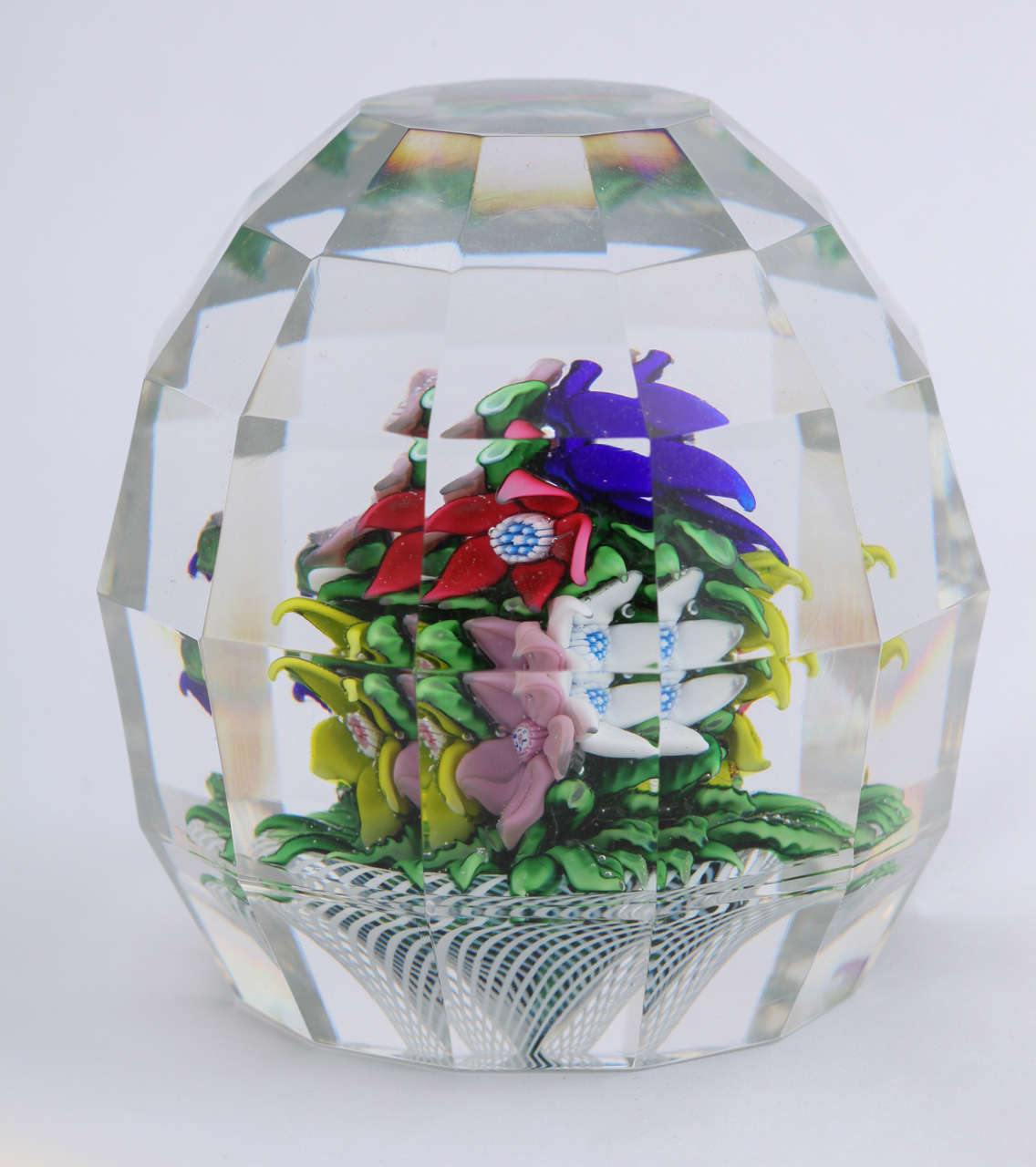 An unique 1978 St. Louis upright bouquet paperweight made up of mulit-color flowers and leaves on a white latticinio basket, flat facets, signed SL1978 in the center of a flower and B-A on the base for Andre Bourlard