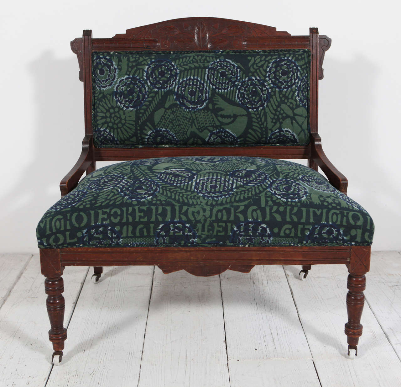 Vintage settee on casters upholstered in African textile.