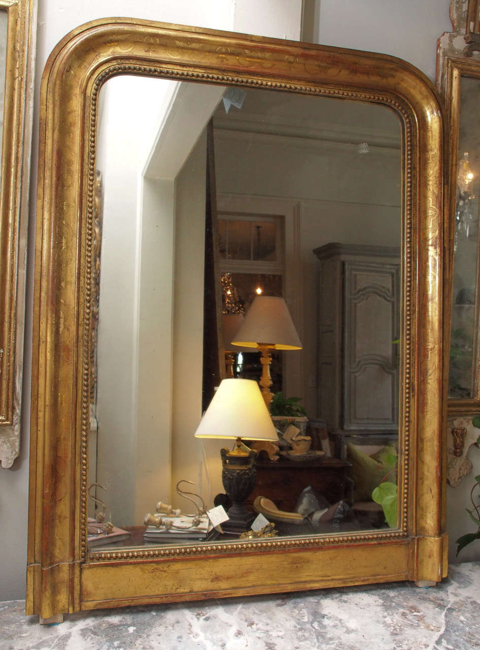 19th century carved and gilded wood mirror with a flower motif. Beautiful patina