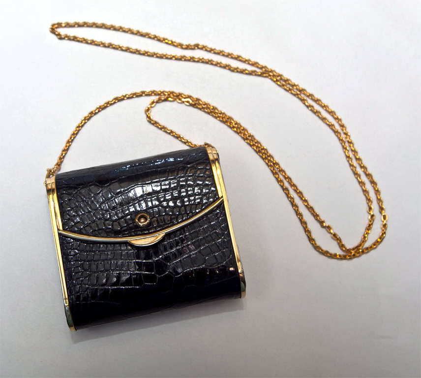 funkyfinders.com is pleased to present this luxury skin clutch from the house of judith leiber. a rich black alligator/crocodile surround is accented with opulent brass appointments. the interior boasts lavish gold leather as well as the