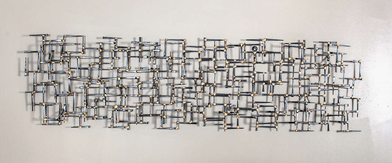 Late 1960 abstract sculpture made of iron masonry nails. The dark patina of the iron contrasts with the bright gold of the brazing solder that joins the elements.

This item can be seen at !stDibs@NYDC Showroom, 200 Lexington Avenue, 10th Floor.