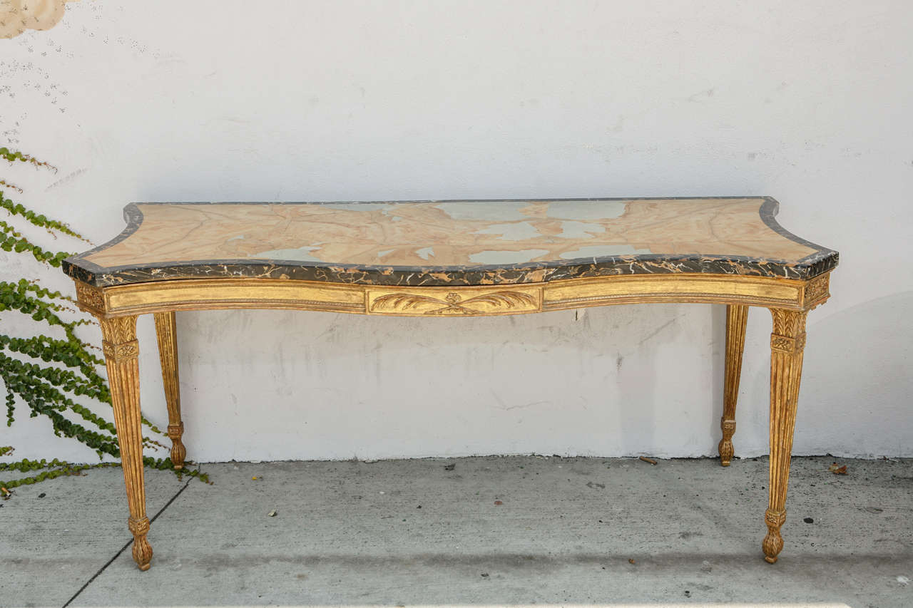 Early 19th century English Giltwood Console with very fine carving and a specimen marble top from the Asprey Store in London. A very rare and exceptional piece.