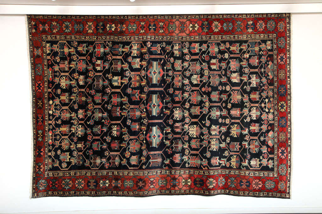 This 1910 Bibibaft Bakhtiari rug consists of a cotton warp, handspun wool weft and handspun hand-knotted wool pile. The deep indigo, bright reds, pinks and blues were all created using organic vegetable dyes. This carpet originates from the Nooch