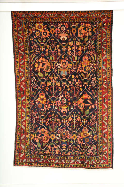 This 1910 Bakhtiari rug from the village of Chahal Shotor consists of a cotton warp and handspun wool weft and hand-knotted pile. Its beautiful bright colors are derived from organic vegetable dyes, and include blues, reds, golds, pinks and greens.
