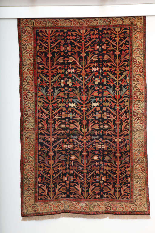 This 1900-1910 Persian Malayer carpet consists of a cotton warp, handspun wool weft and hand-knotted handspun wool pile. Its bright oranges, reds, blues, and golds were created using organic vegetable dyes. The neutral creams and browns throughout