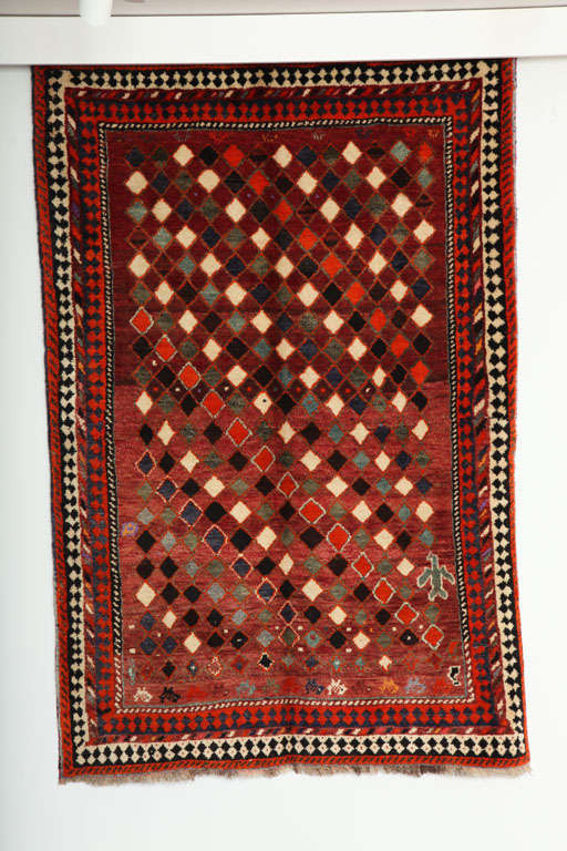 This 1930 Persian Gabbeh rug consists of a handspun wool warp, weft and hand-knotted pile. Its rich reds, greens and blues were all created using natural vegetable dyes; and the creams, browns and blacks exhibit the beautiful natural coloration of
